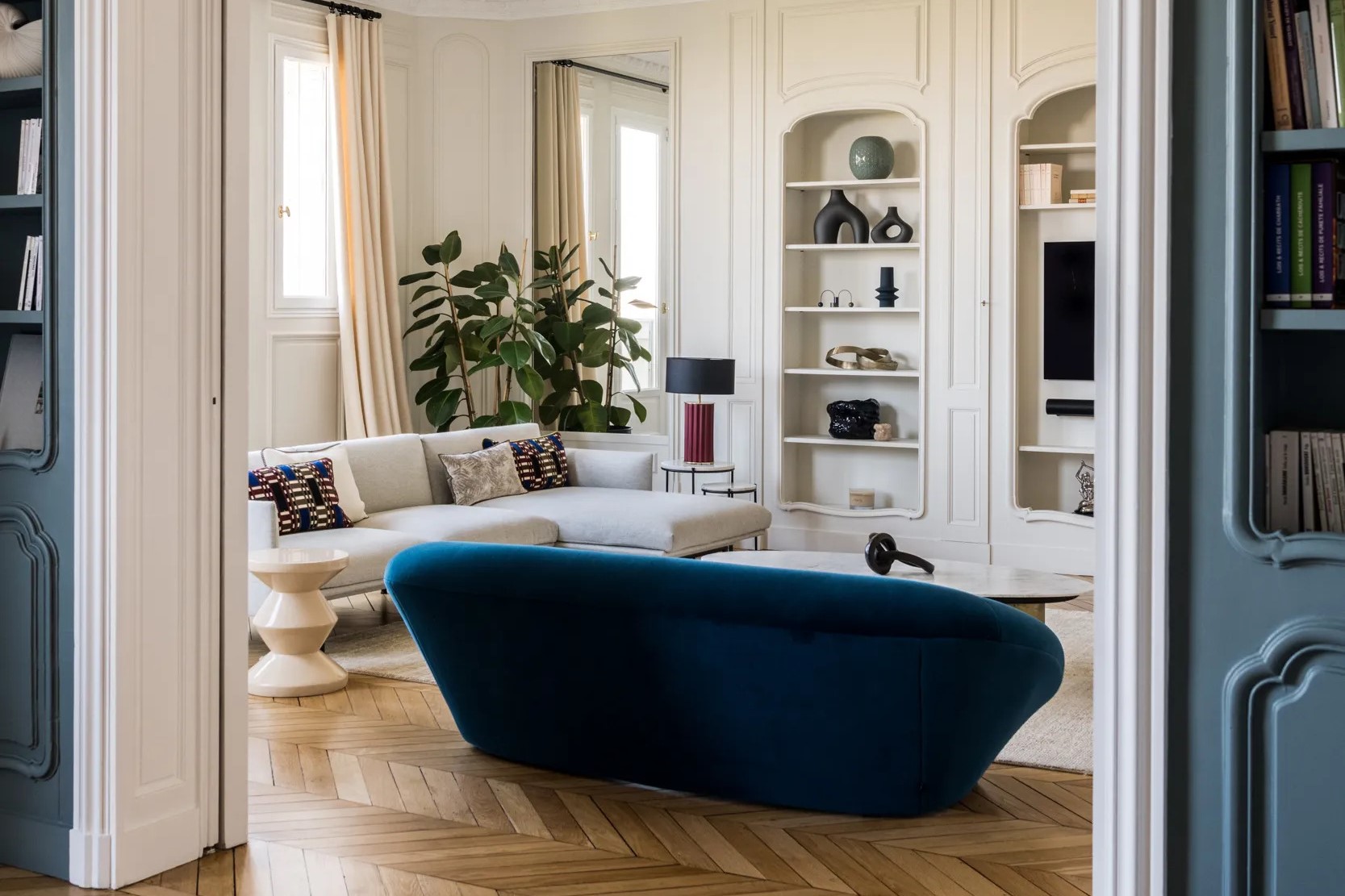 Salon d'un appartement parisien classique rénové, canapé bleu et canapé blanc