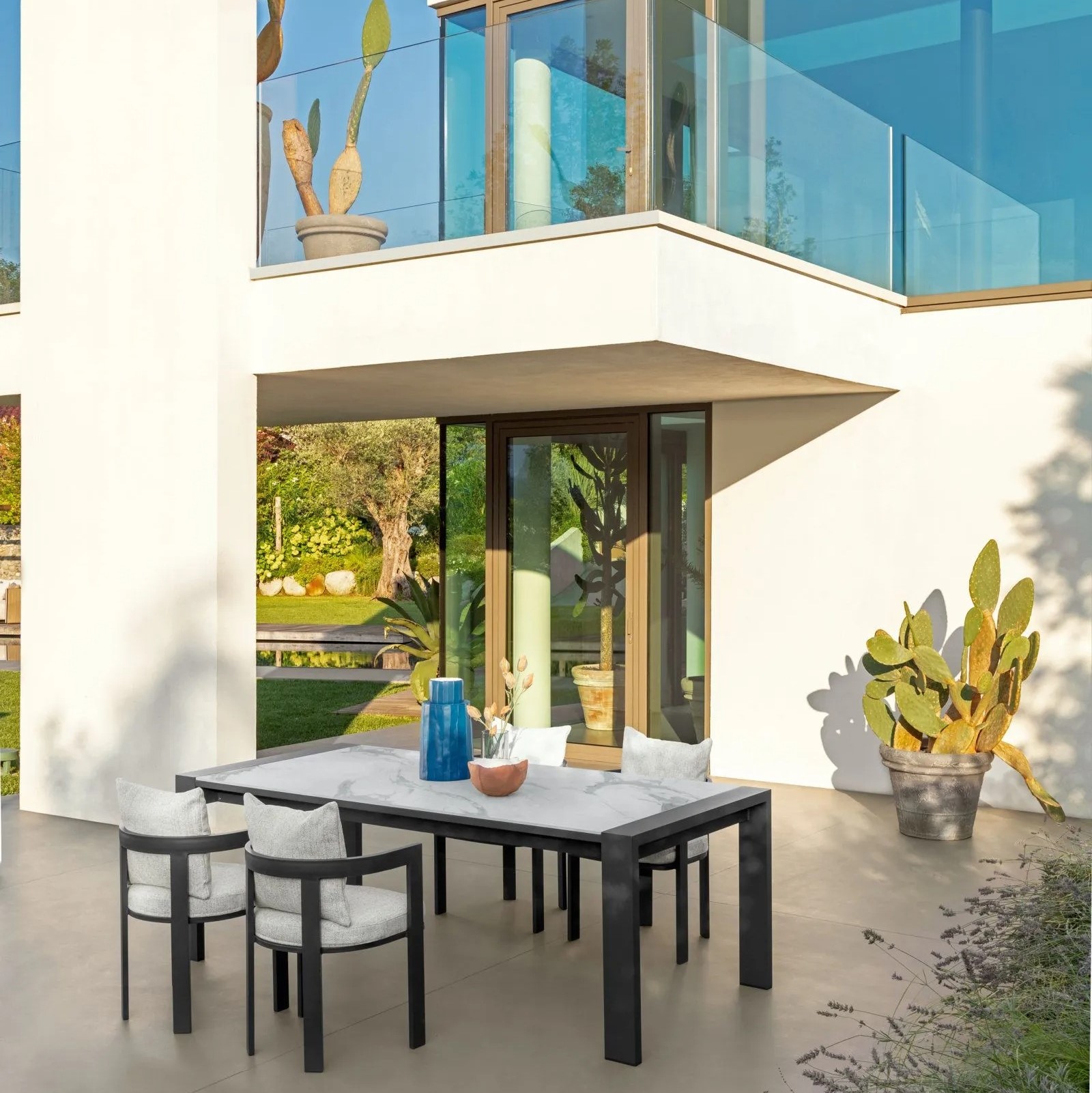 Table de salle à manger outdoor, chaises installées devant une villa contemporaine avec piscine