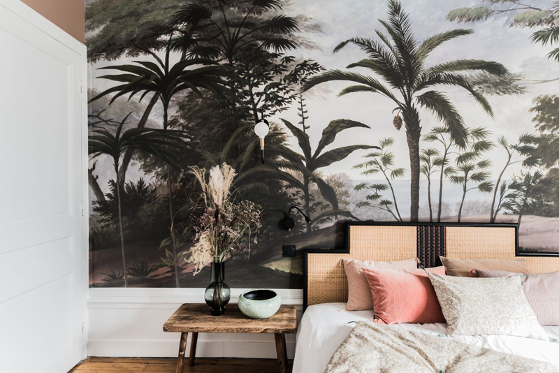 Chambre rehaussée d'un papier peint panoramique exotique et d'une tête de lit en cannage