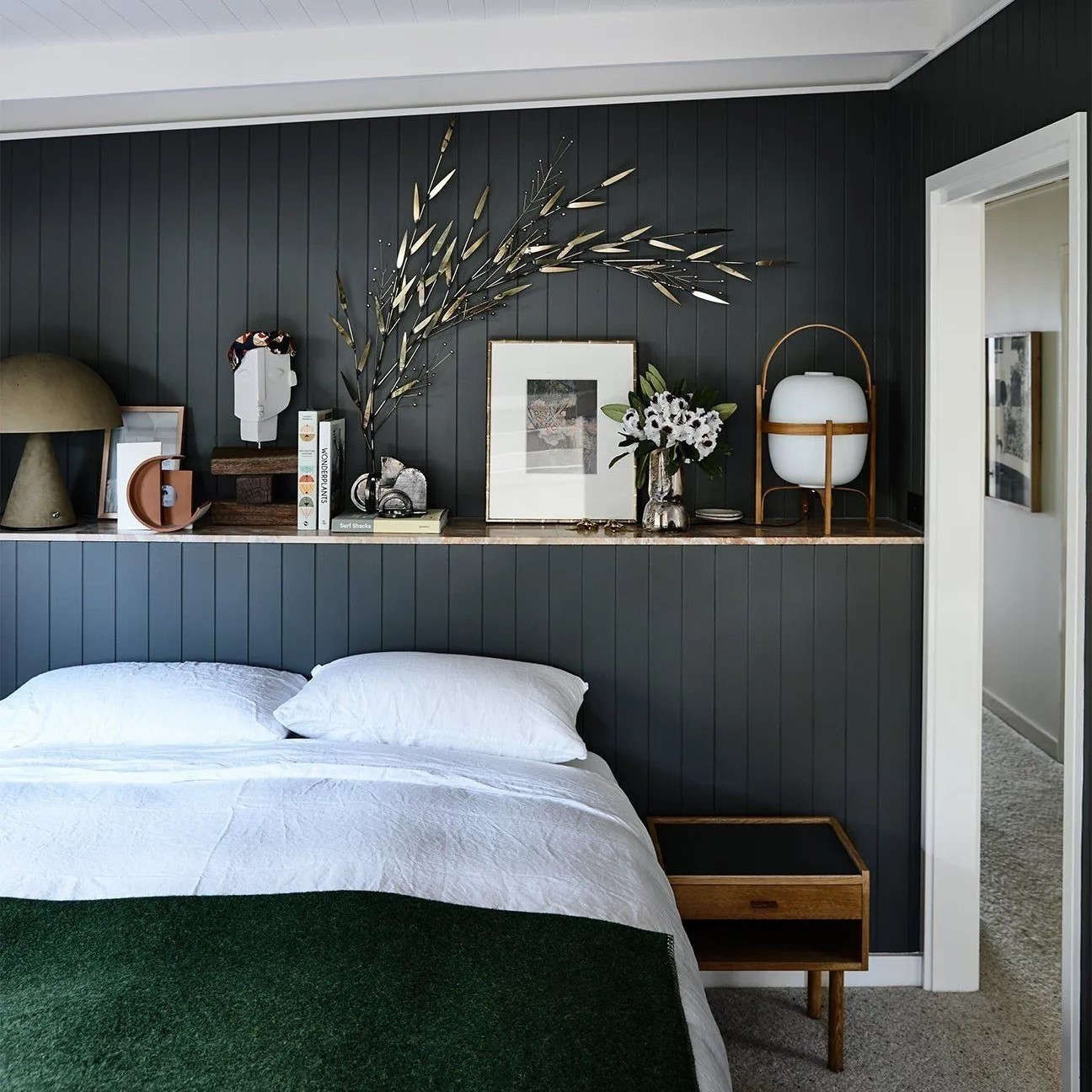 Une chambre à l'esprit maison de campagne avec une tête lit en lambris peint et son étagère