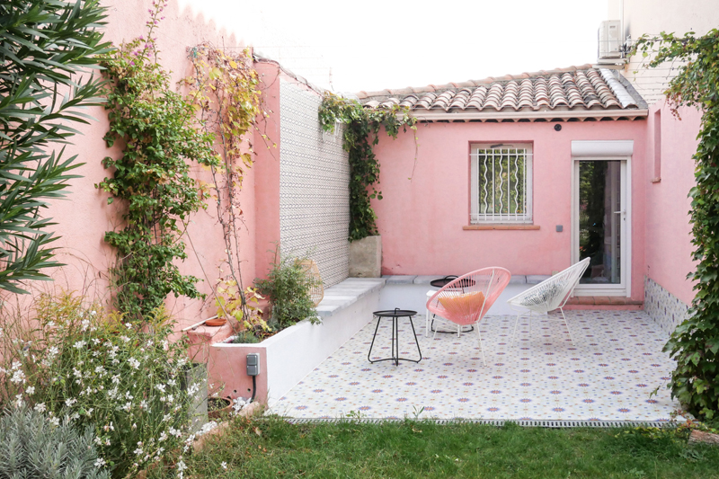 Une terrasse aux couleurs méditerranéennes, entre motifs au sol et peinture rose au mur