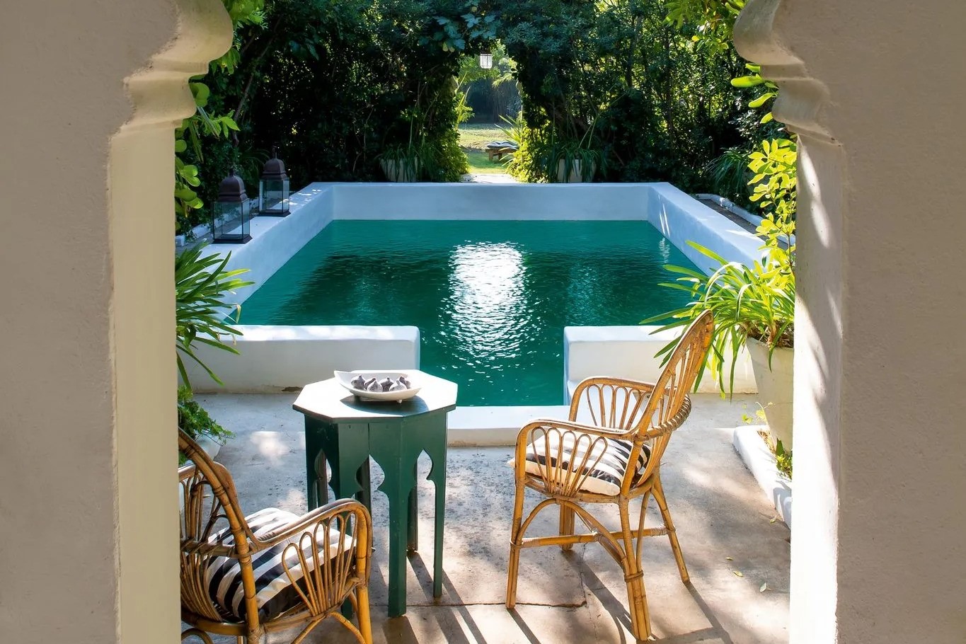 La piscine est soulignée par un muret blanc mettant en valeur la partie peinte en vert émeraude