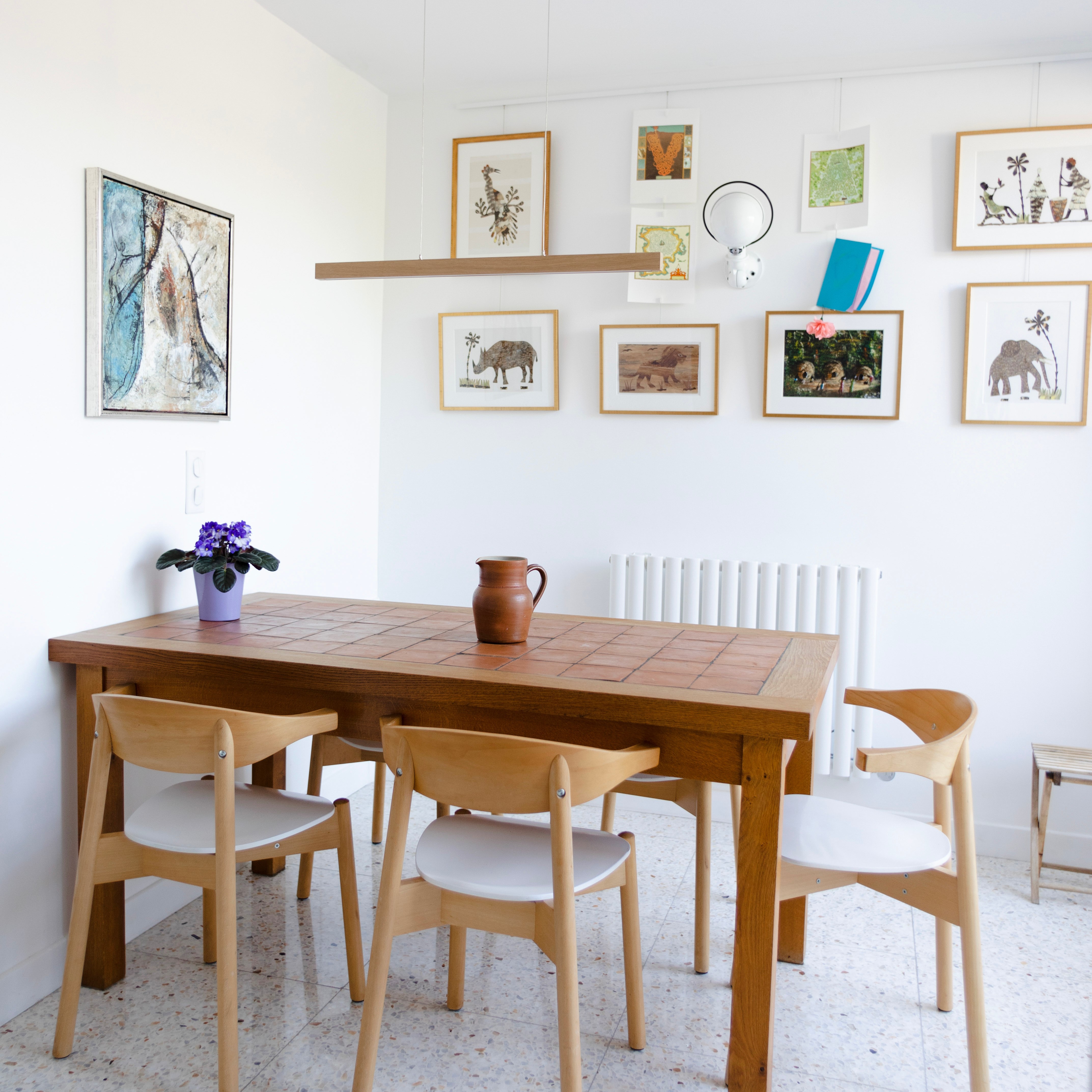 Table de salle à manger en bois avec cadres colorés sur le mur