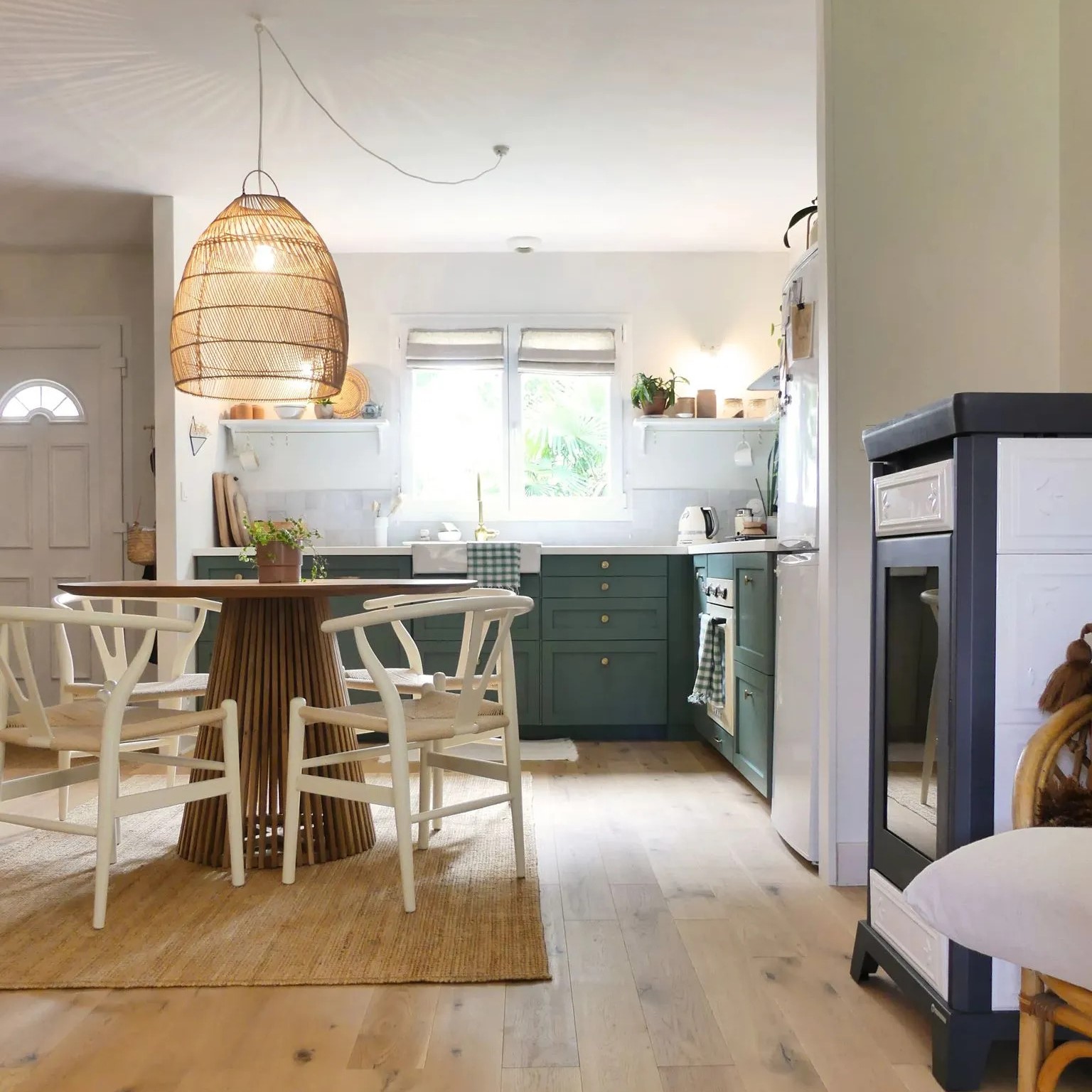 Une petite cuisine ouverte avec meuble vert tendre et table de salle à manger2