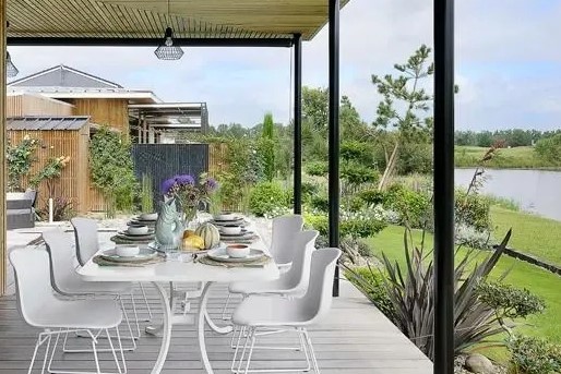 Une terrasse en bois couverte donnant sur le lac