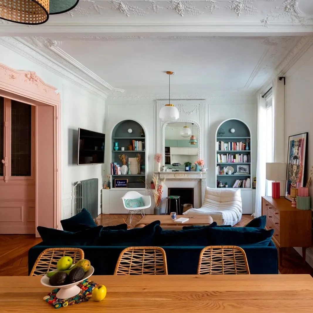 Séjour d'un appartement parisien classique joliment coloré avec encadrement de porte rose