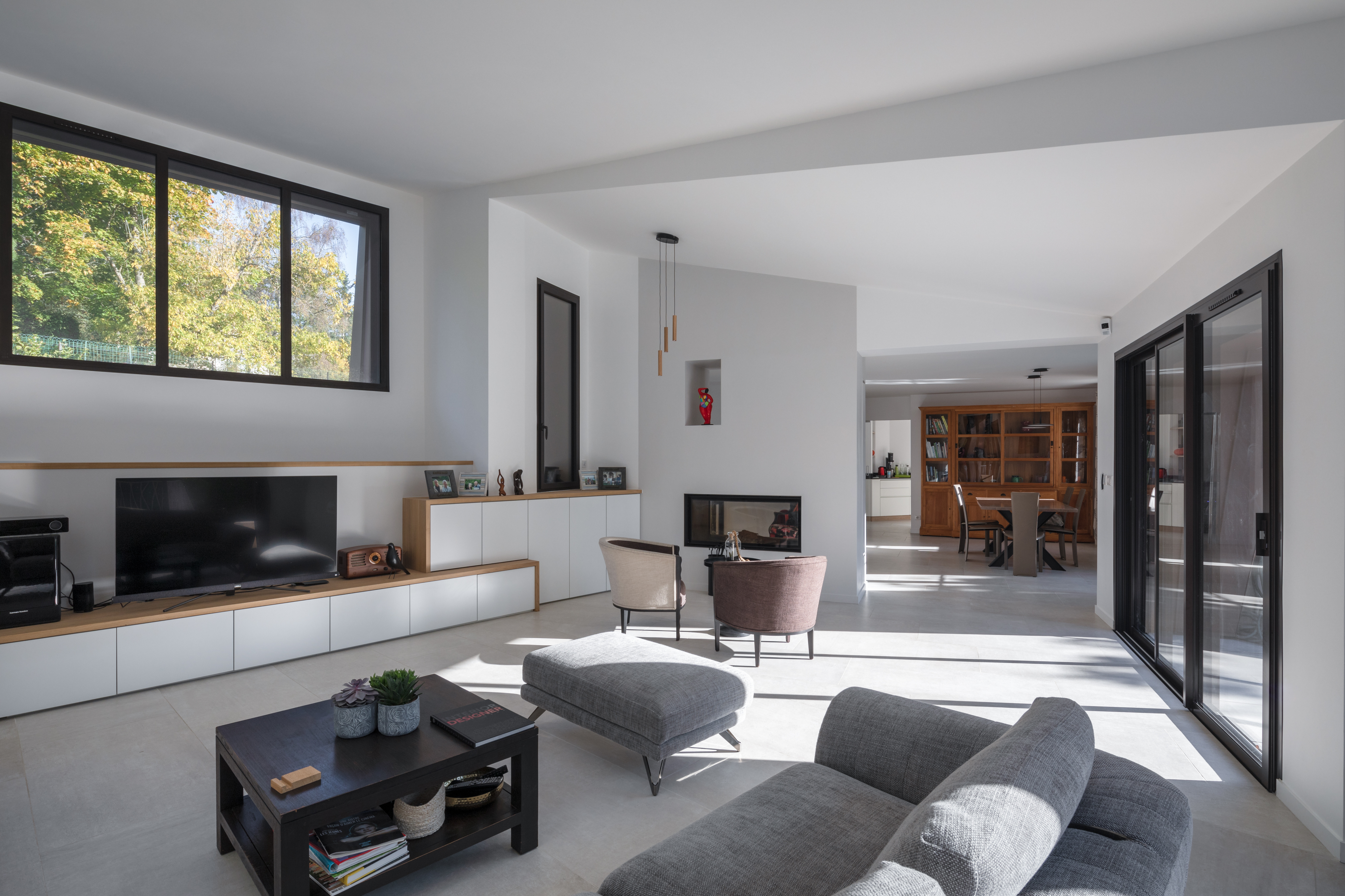 Séjour installé dans l'extension contemporaine d'une maison, grands volumes et baies vitrées