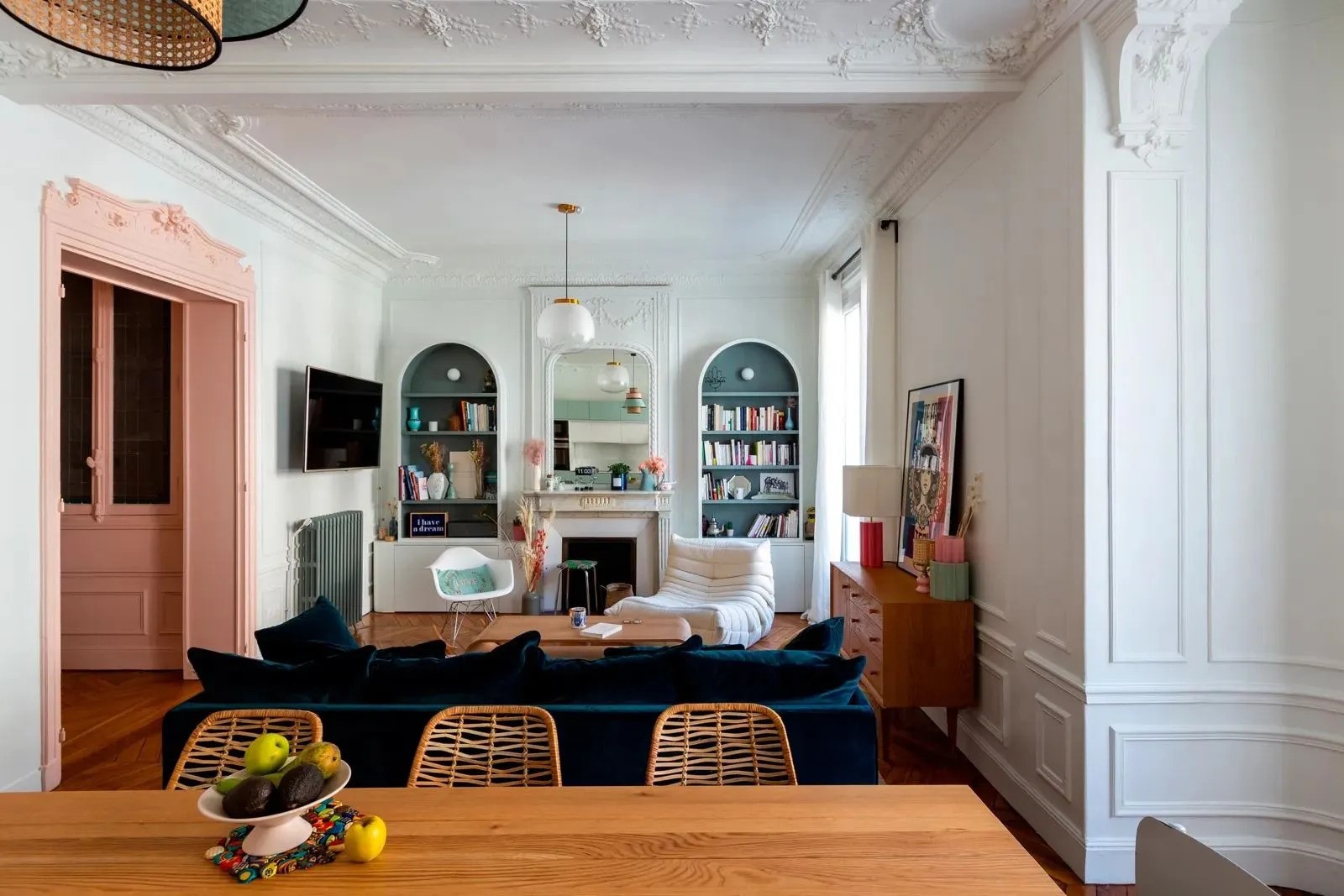 Séjour d'un appartement parisien classique joliment coloré avec encadrement de porte rose